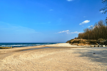 The rugged coast of the Baltic Sea with a sandy beach and wooden breakwaters in Poland...