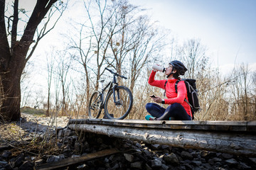 woman cyclist drinking water from a flask