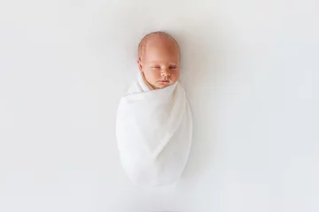 Fototapeten Newborn baby sleeps in white winding on a white background © studiomay