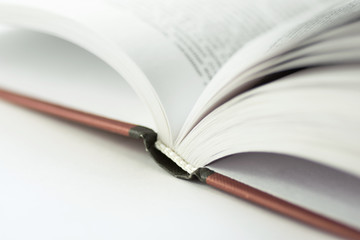 Open book lying on white desktop. College school university education learning literacy concept. Poster banner with copy space. Abstract conceptual image