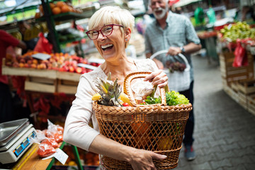 Senior woman buying fresh fruits and vegetables at the local market