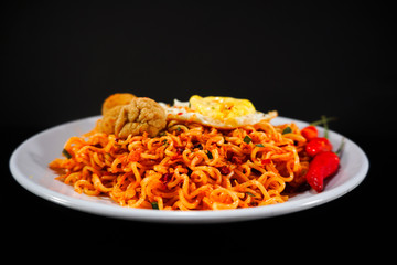 Spicy Noodle with meatball and fried egg isolated on black background