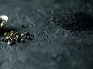 A set of spices on a dark stone background.