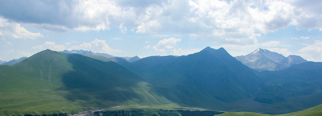 The Caucasus Mountains, high mountains, green meadows and snow-capped mountains.
