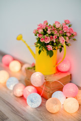 pink roses in yellow watering can