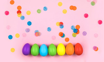 Colored Easter eggs on pink background. Flatlay.