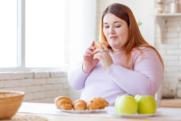 Nice thoughtful woman looking at the apple