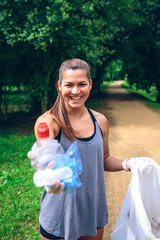 Girl showing the garbage she has collected. Selective focus on girl in background
