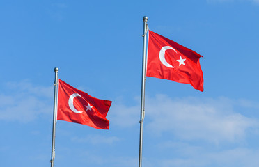 Turkish national flags flying in the wind against a blue sky