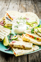 Mexican traditional food, quesadilla with chicken and vegetables, with white sauce, rustic wooden background copy space