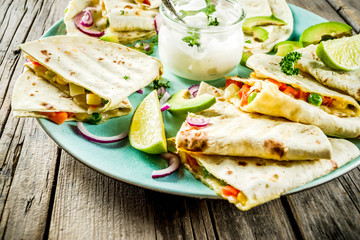 Mexican traditional food, quesadilla with chicken and vegetables, with white sauce, rustic wooden background copy space