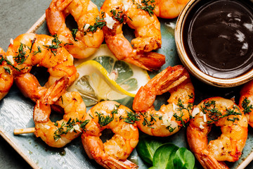 Delicious roasted shrimps on plate with lemon