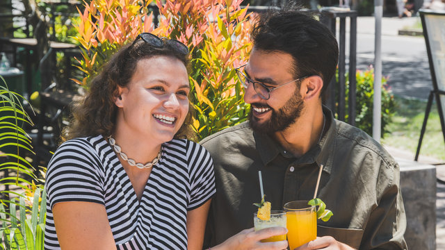 Couple in love having fun and fresh drinks at restaurant on travel excursion – Young happy tourists enjoying happy moments at open air bar – Relationship concept -  Summer warm filter – Image