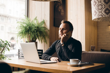 Young handsome businessman conducting negotiations with investors. Electronic business. Alternative...