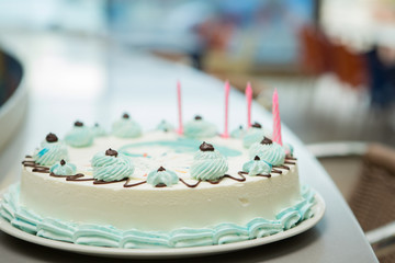 Blue Birthday cake with Candles in the Restaurant with no people