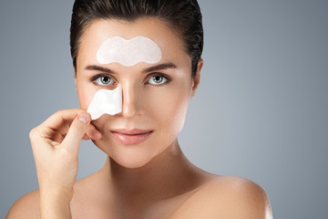 Beautiful woman with a cleansing pore strips on her face