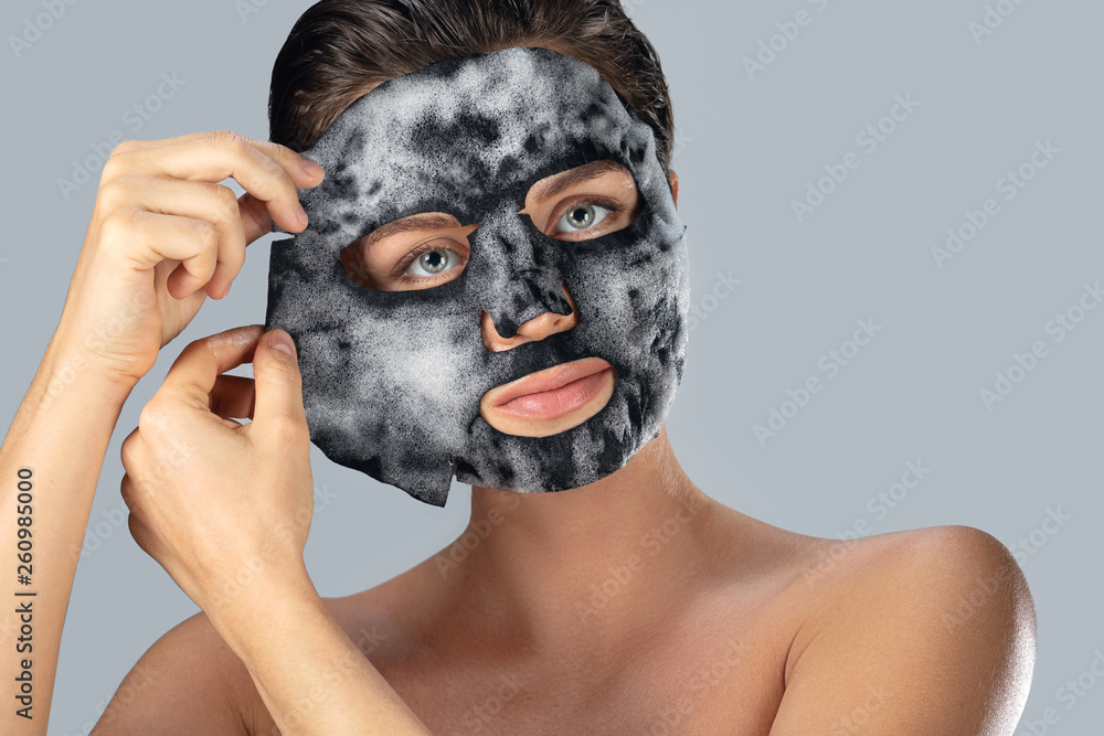 Wall mural Woman with  bubble sheet mask on her face