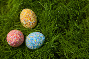 Colored Easter eggs on the lawn in the green grass