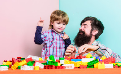 Father son game. Dad and kid build plastic blocks. Child care development. Family leisure. Father and son create constructions. Bearded man and son play together. Surefire ways to bond with your son
