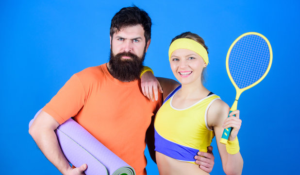 Train hard, win easy. Happy woman and bearded man workout in gym. Sporty couple training with fitness mat and tennis racket. Athletic Success. Sport equipment. Strong muscles and body. Train and win