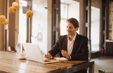 Young handsome businessman conducting negotiations with investors. Electronic business. Alternative...