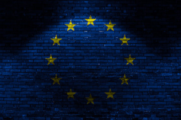 EU flag on brick wall at night