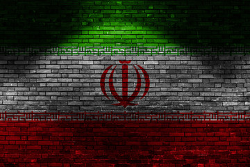 Iran flag on brick wall at night