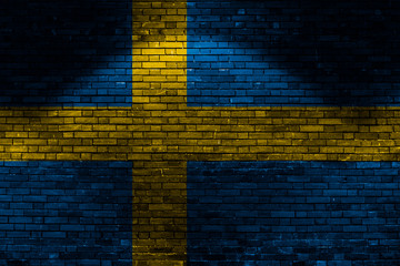 Sweden flag on brick wall at night