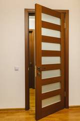 Keyhole and metal handle of a wooden door. brown wooden door with glass