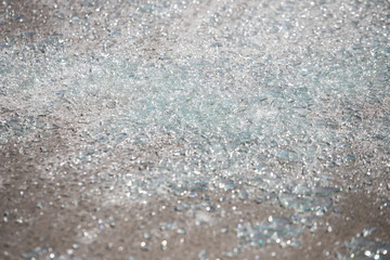 Shards of broken car glass on the asphalt road