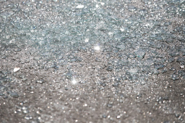 Shards of broken car glass on the asphalt road