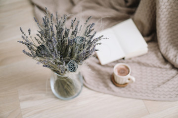 Dried flowers and a cup of cappuccino  with book on wooden background. top view. flatlay