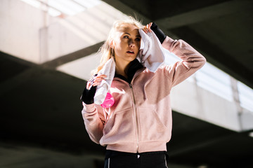 Woman drinks water after running. Sporty girl thirsty. Girl having sports drink.