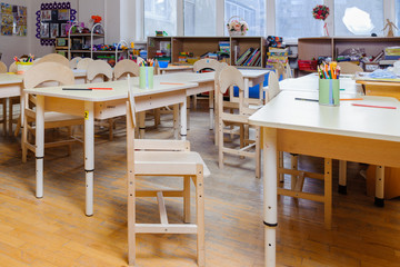 Colored pencils and crayons on the tables in the game room.