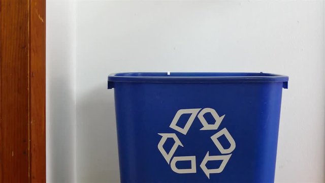 Hand is adding shredded paper to recycling bin view from inside