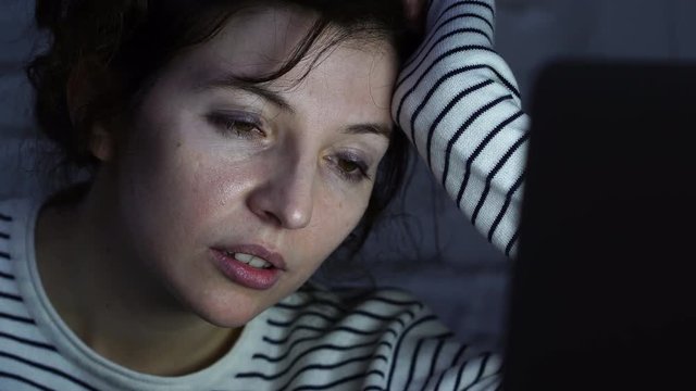 4k close up of Overwhelmed and tired female student falling asleep working or studying late at night on laptop. Feeling fatigued and sleepy trying to concentrate. Final exams or overwork concept.