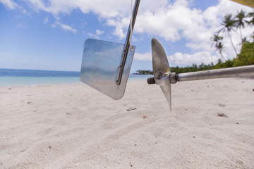 Propeller, rudder and driveshaft of a fisher boat with reflection on the Metall a white beach...