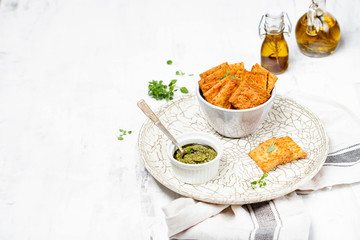 A bowl with crispy cheese crackers on white background