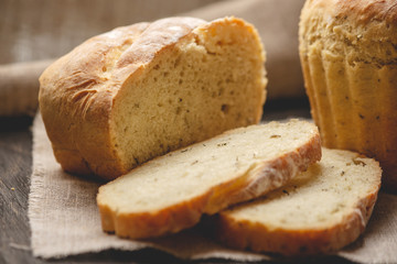 Homemade natural fresh bread with a Golden crust on a napkin on an old wooden background . Baking bakery products