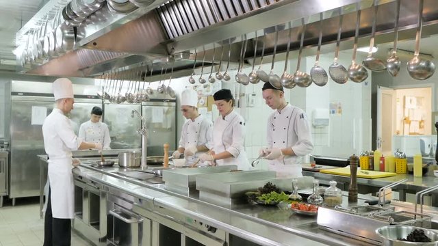 Cooks prepare meals on the stove in the kitchen of the restaurant or hotel