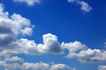 Naklejka na ściany i meble Big white fluffy clouds in the blue sky.Summer background.