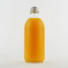 Glass bottle of fresh orange juice, isolated, white background