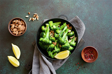 Broccoli with lemon and almond in a frying pan. Nutrition concept