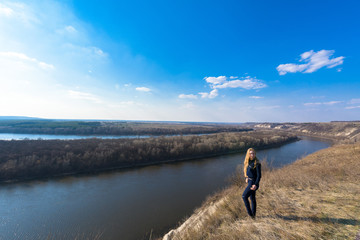 girl on the river Bank. wide channel, blue sky. mountain shore