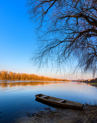Obraz premium panorama of the river with a boat . wide channel, blue sky. mountain shore