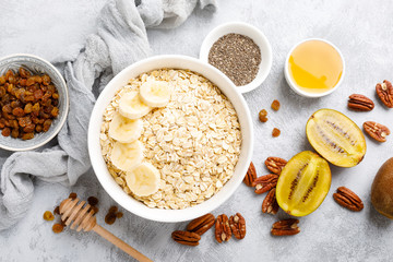 Oat flakes with fruits, nuts and honey in bowl