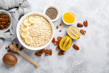 Oat flakes with fruits, nuts and honey in bowl