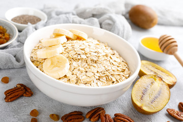 Oat flakes with fruits, nuts and honey in bowl