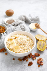 Oat flakes with fruits, nuts and honey in bowl