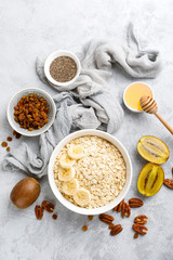 Oat flakes with fruits, nuts and honey in bowl